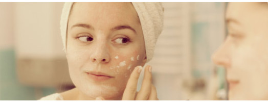 woman applying cream on face