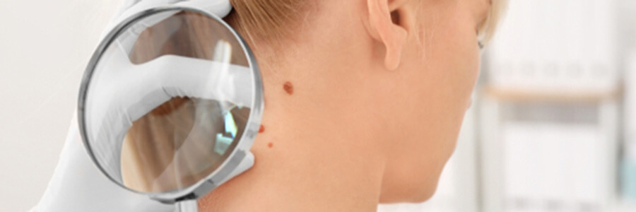 Doctor examining female patient with magnifier in clinic