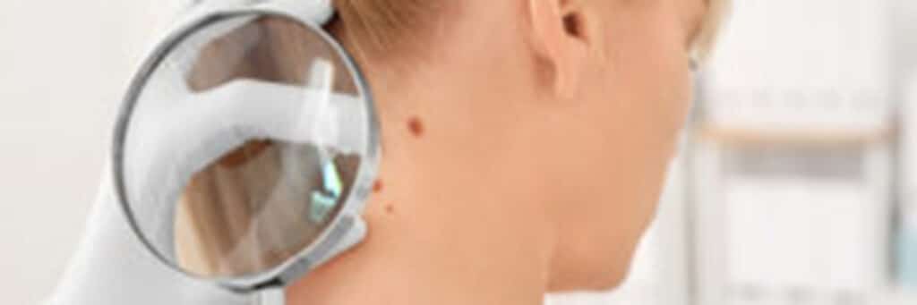 Doctor examining female patient with magnifier in clinic